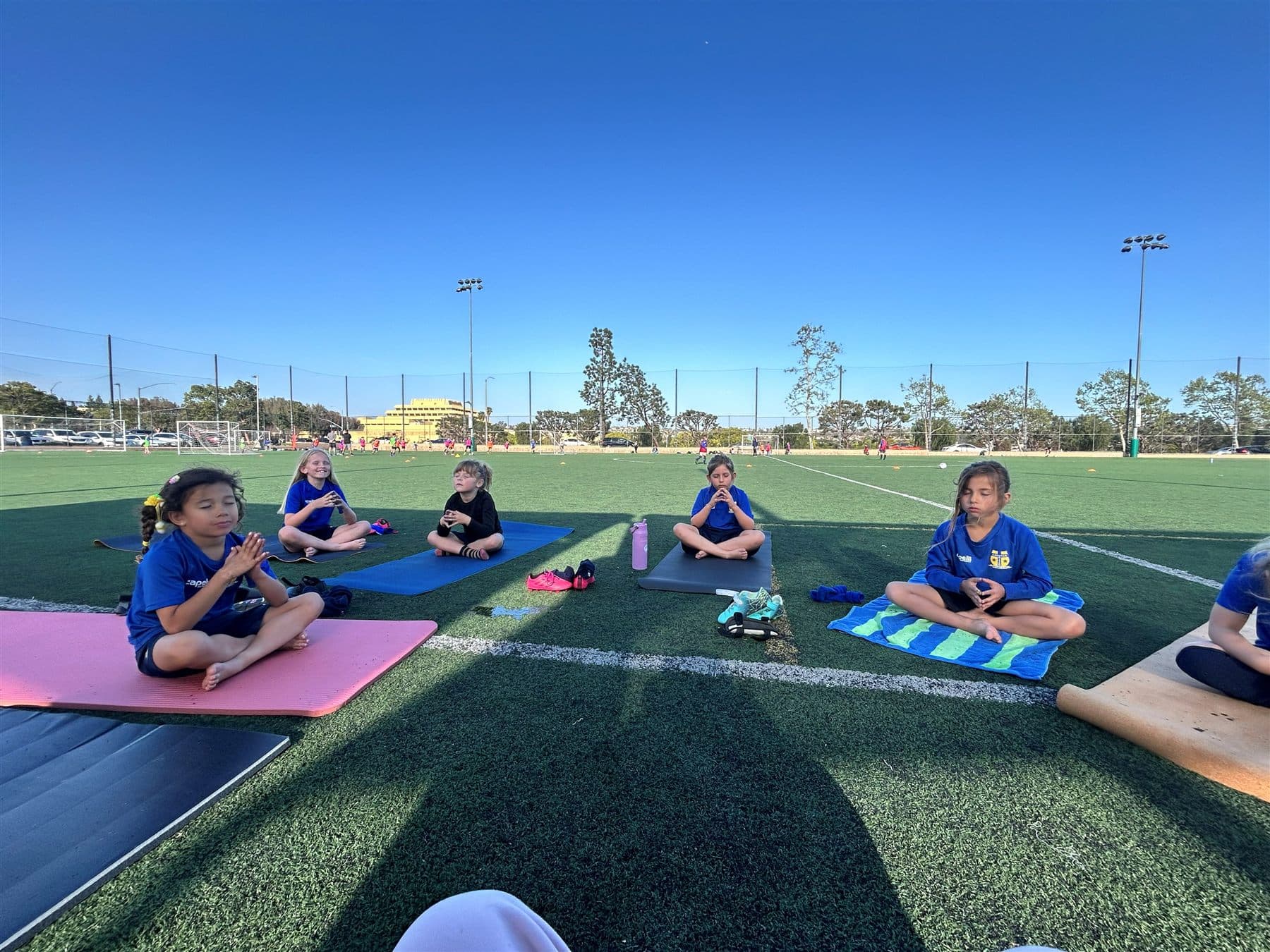 Athletes sitting and meditating together on the field