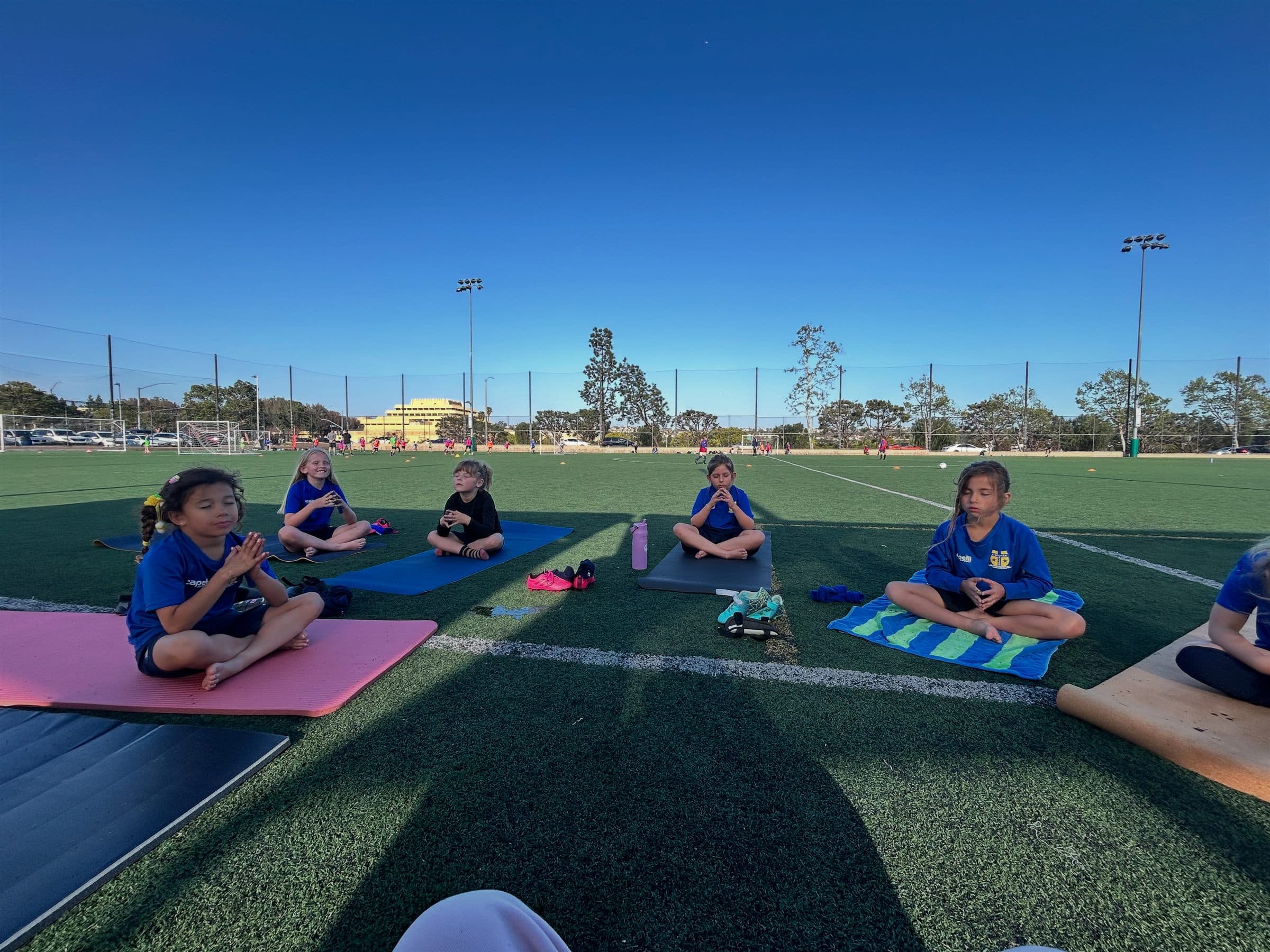 Athletes sitting in stillness together on the training field