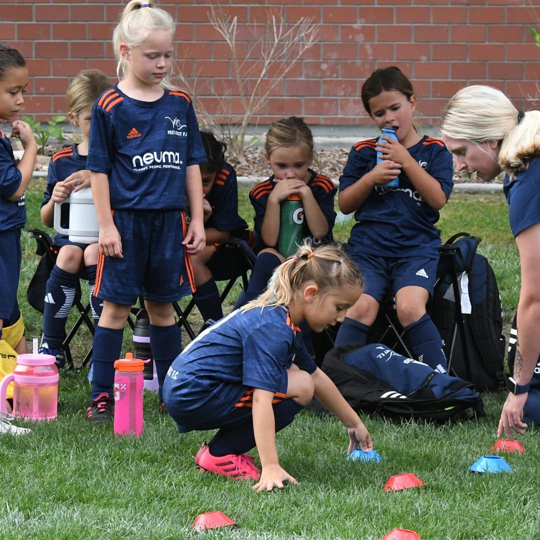 Young athletes setting up a cone drill in training