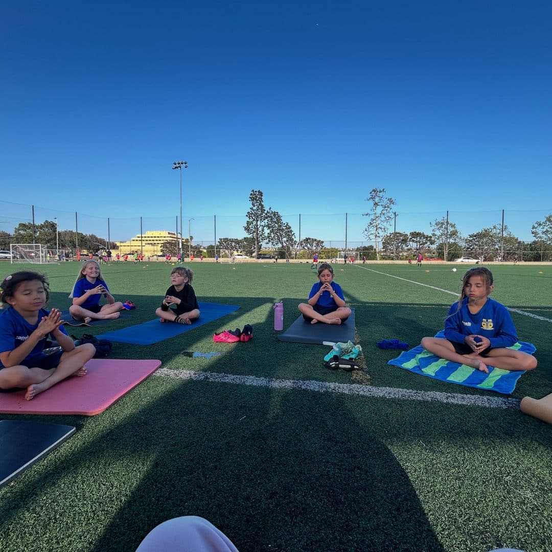 Players sitting for a mindfulness session on the pitch