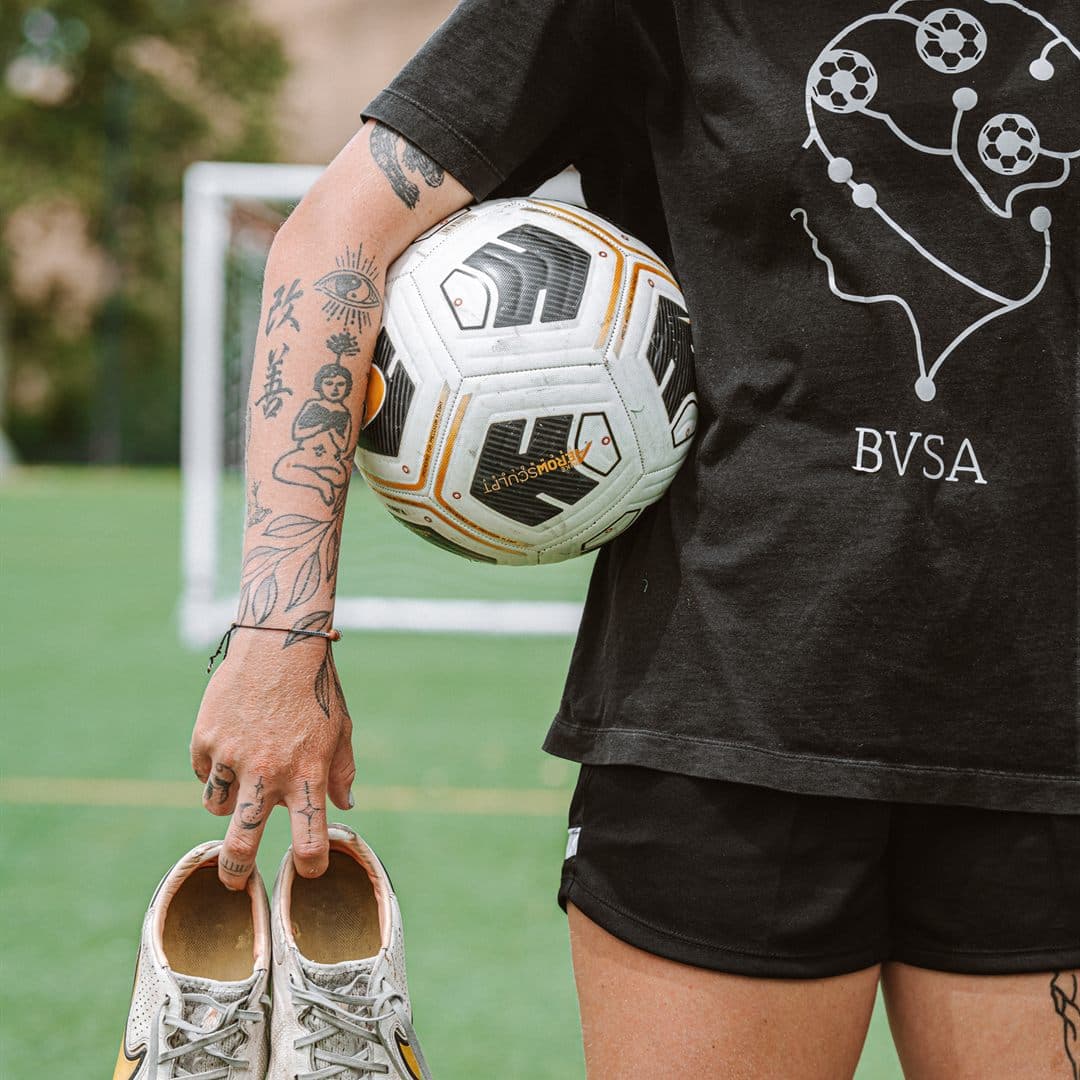 Coach Bella in a BVSA training top holding a ball