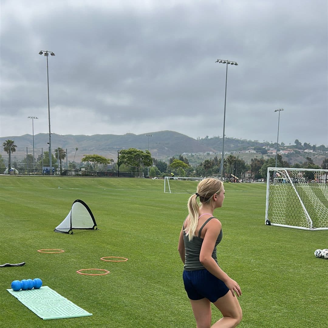 Coach Bella running resistance-band sprints in a training session